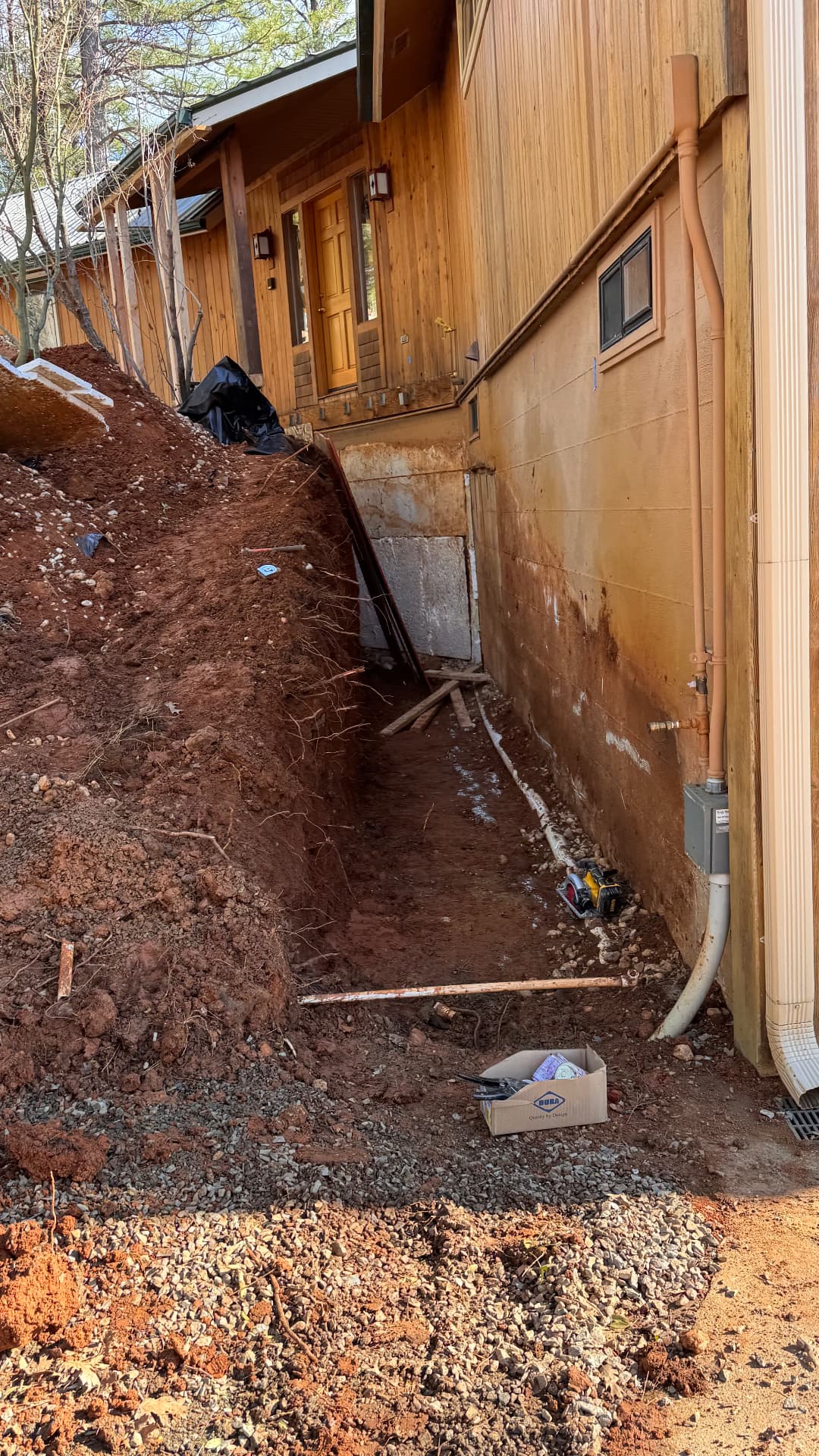 Foundation French drain system installed alongside a residential building